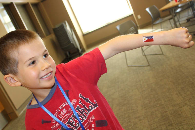 Child showing a Philippine flag sticker on his arm.